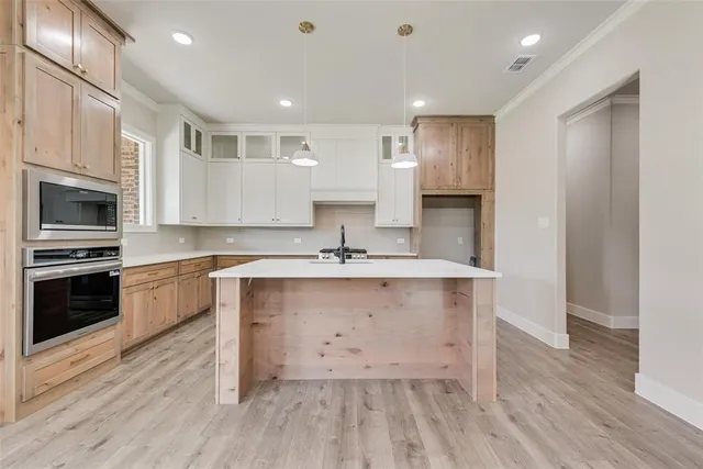 a large kitchen with stainless steel appliances granite countertop a stove a sink and a refrigerator