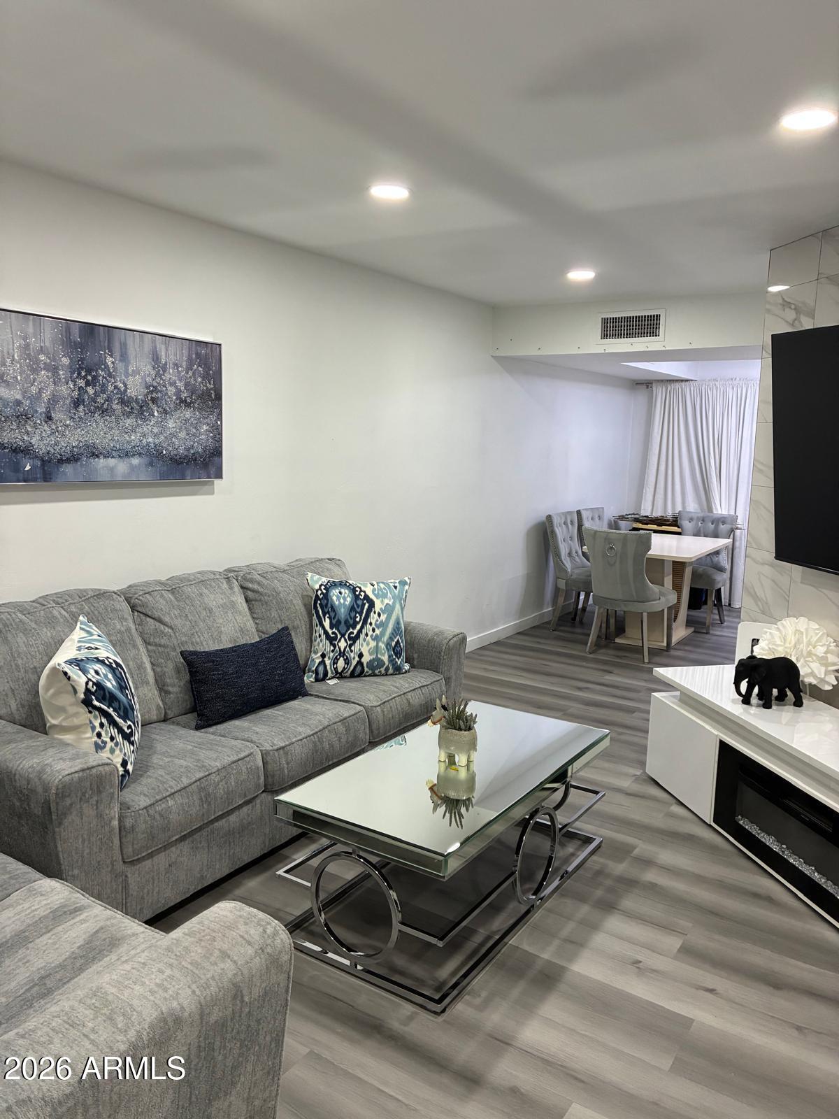 2815 North 52nd Street, Unit 3 Phoenix, AZ 85008 - Photo 1 of 7 a living room with furniture a flat screen tv and kitchen view