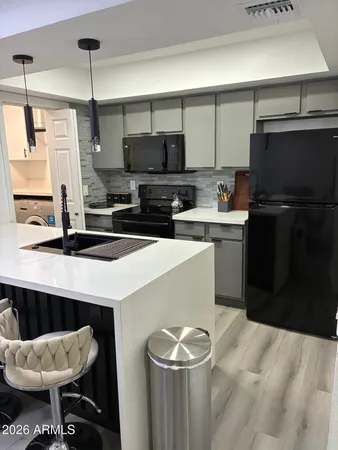 a kitchen with a sink a stove and chairs