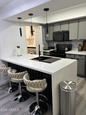 a kitchen with a sink a stove and chairs