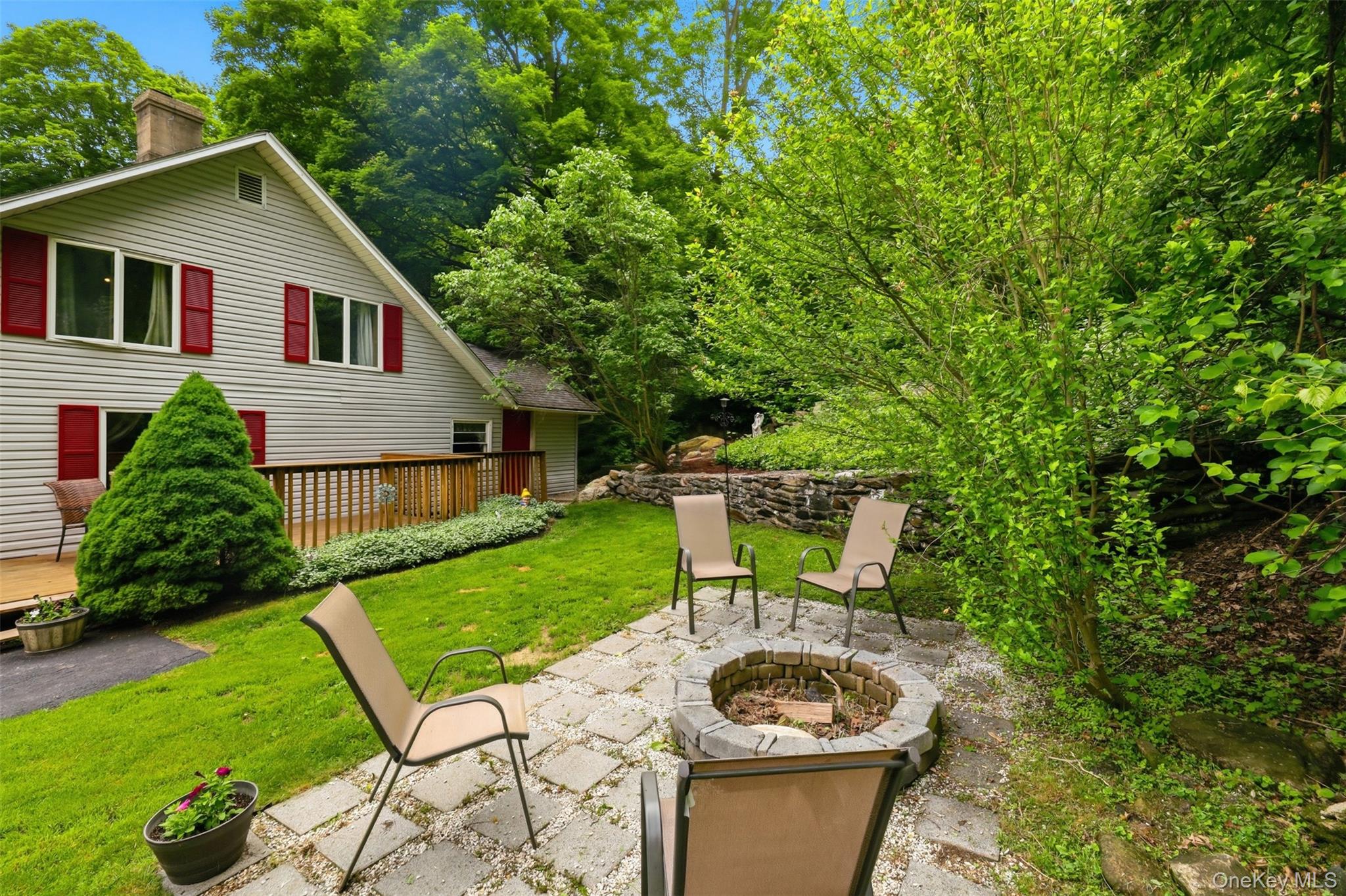 236 Hosner Mountain Road Hopewell Junction, NY 12533 - Photo 42 of 46 Relaxing outdoor living area featuring a stone fire pit, paver patio, and a wooden deck