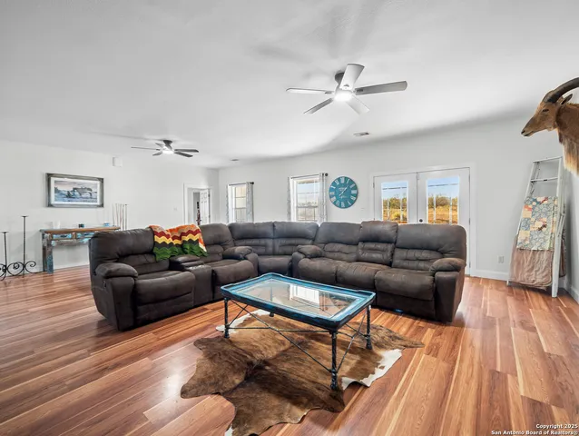 a living room with furniture a ceiling fan and a rug