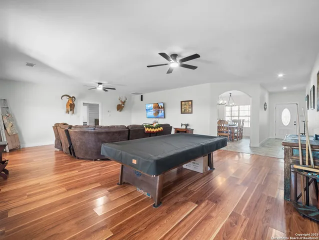 a living room with furniture a wooden floor and a chandelier