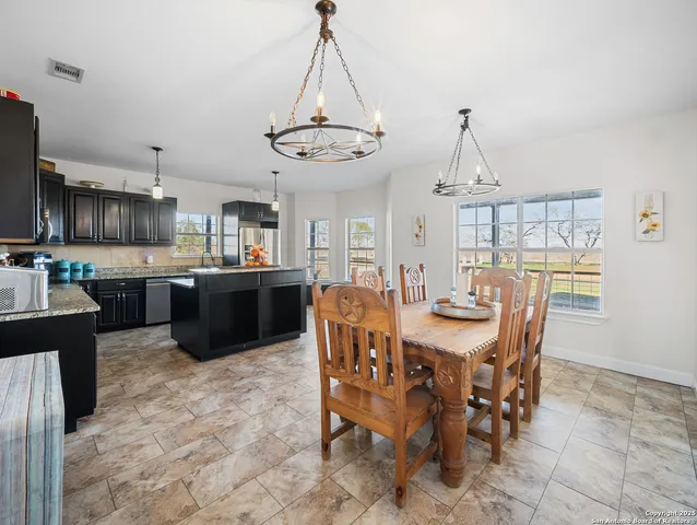 a view of a dining room and livingroom with furniture wooden floor a chandelier