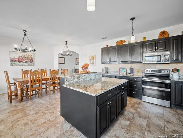 a kitchen with stainless steel appliances granite countertop a stove and a center island