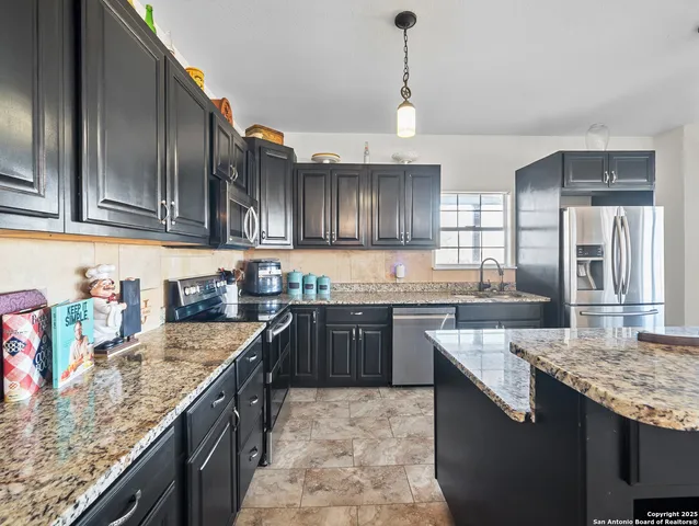 a kitchen with granite countertop stainless steel appliances and wooden cabinets
