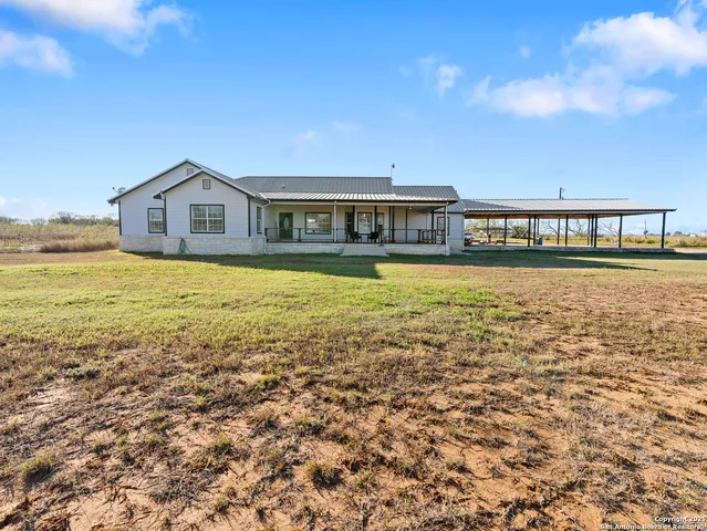 a view of a big house with a big yard and large trees