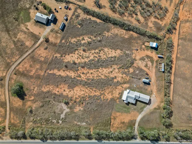 an aerial view of a house with a yard