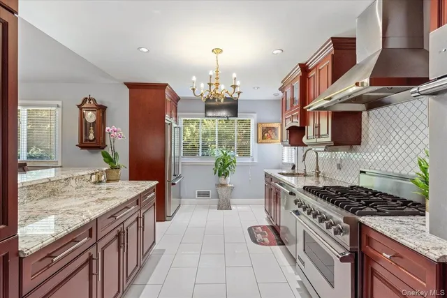 a kitchen with stainless steel appliances granite countertop a stove a sink dishwasher and a wooden cabinets