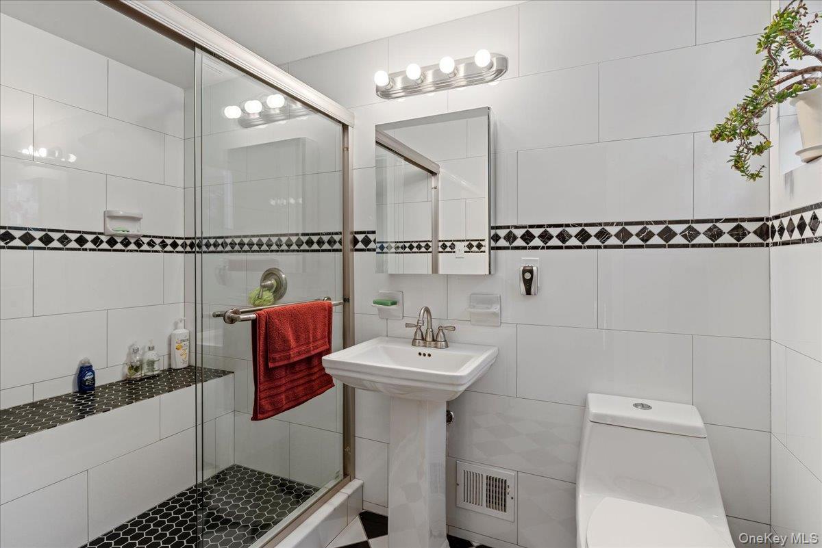 269 Hungry Harbor Road Valley Stream, NY 11581 - Photo 15 of 34 a bathroom with a sink a toilet and shower