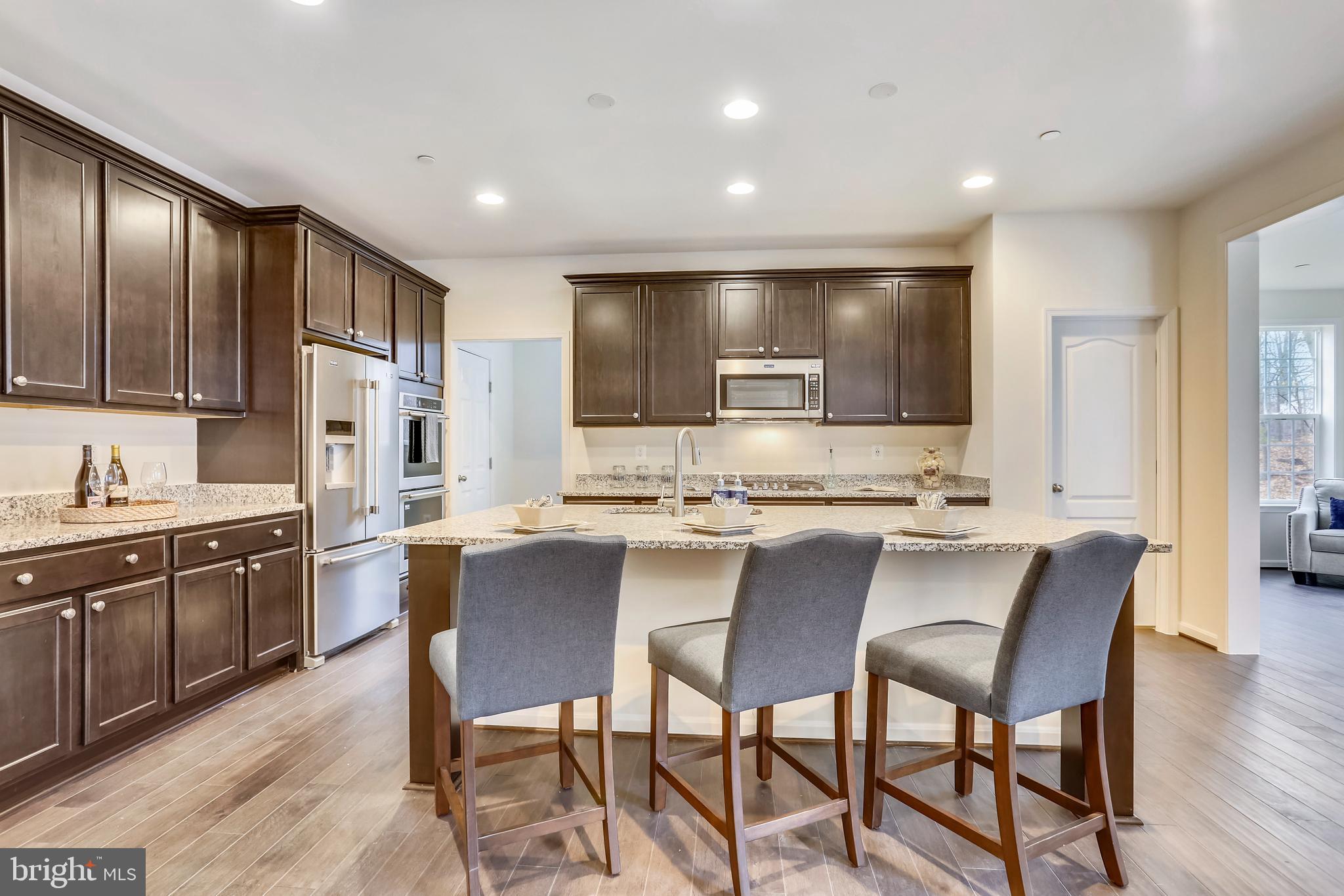3916 Diplomat Avenue Bowie, MD 20721 - Photo 8 of 18 a kitchen with stainless steel appliances granite countertop table chairs sink and stove