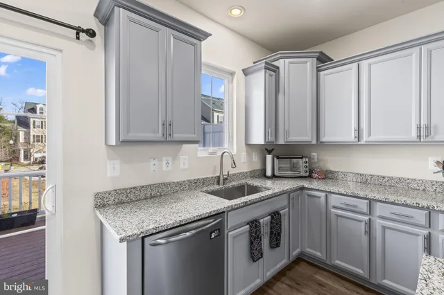 a kitchen with stainless steel appliances granite countertop a sink and a granite counter tops with wooden floors