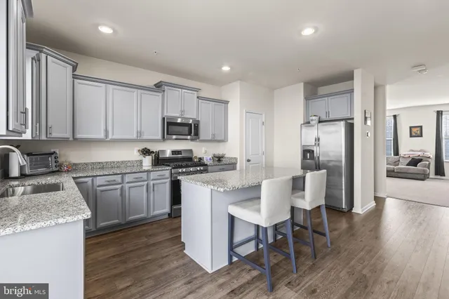 a kitchen with granite countertop white cabinets and stainless steel appliances