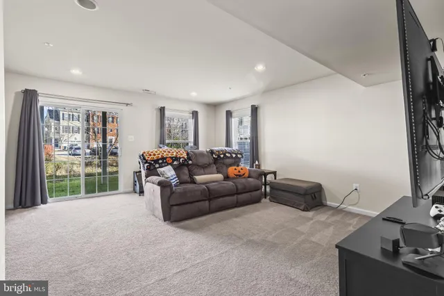 a living room with furniture a flat screen tv and a window