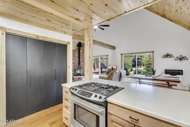 a kitchen with a stove a sink and wooden floor