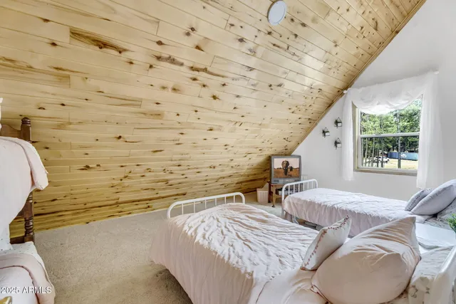 a bed sitting in a bedroom next to a window with wooden floor