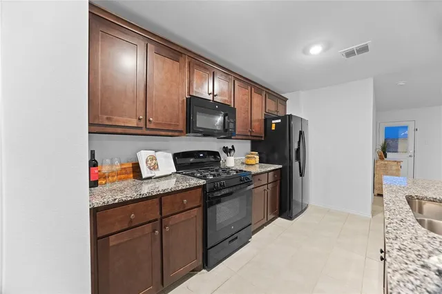 a kitchen with stainless steel appliances granite countertop a refrigerator stove and sink