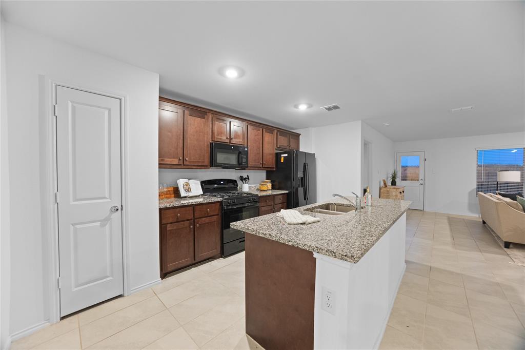 6436 Auburn Dl Road Pilot Point, TX 76258 - Photo 4 of 22 a kitchen with stainless steel appliances granite countertop a sink stove and refrigerator