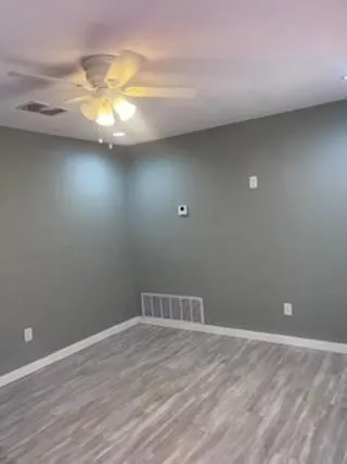 a view of a room with wooden floor and fan