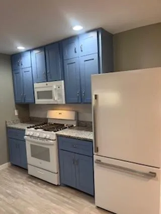 a kitchen with wooden cabinets and white appliances