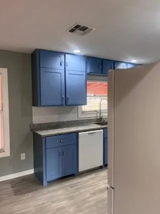 a kitchen with stainless steel appliances granite countertop a sink and a stove with wooden floor