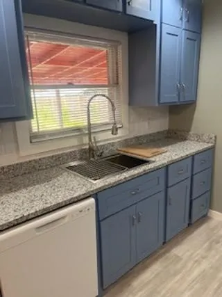 a kitchen with sink a window and cabinets