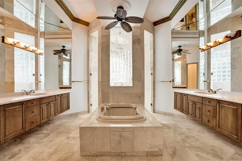 a spacious bathroom with a tub sink shower and mirror