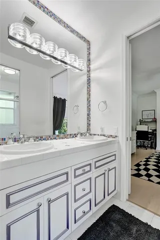 a bathroom with a sink a mirror and a shower