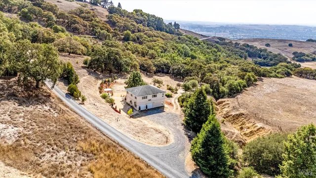 a view of a house with a tree in front of it