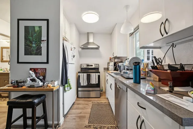 a kitchen with granite countertop a sink stove and cabinets