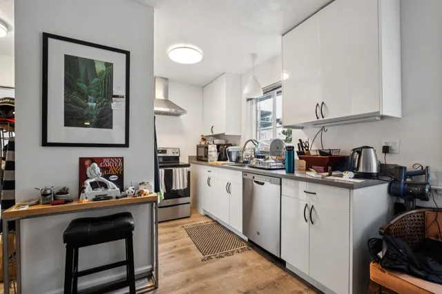 a kitchen with stainless steel appliances granite countertop a sink stove and cabinets