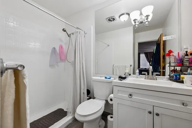 a bathroom with a sink vanity mirror and toilet