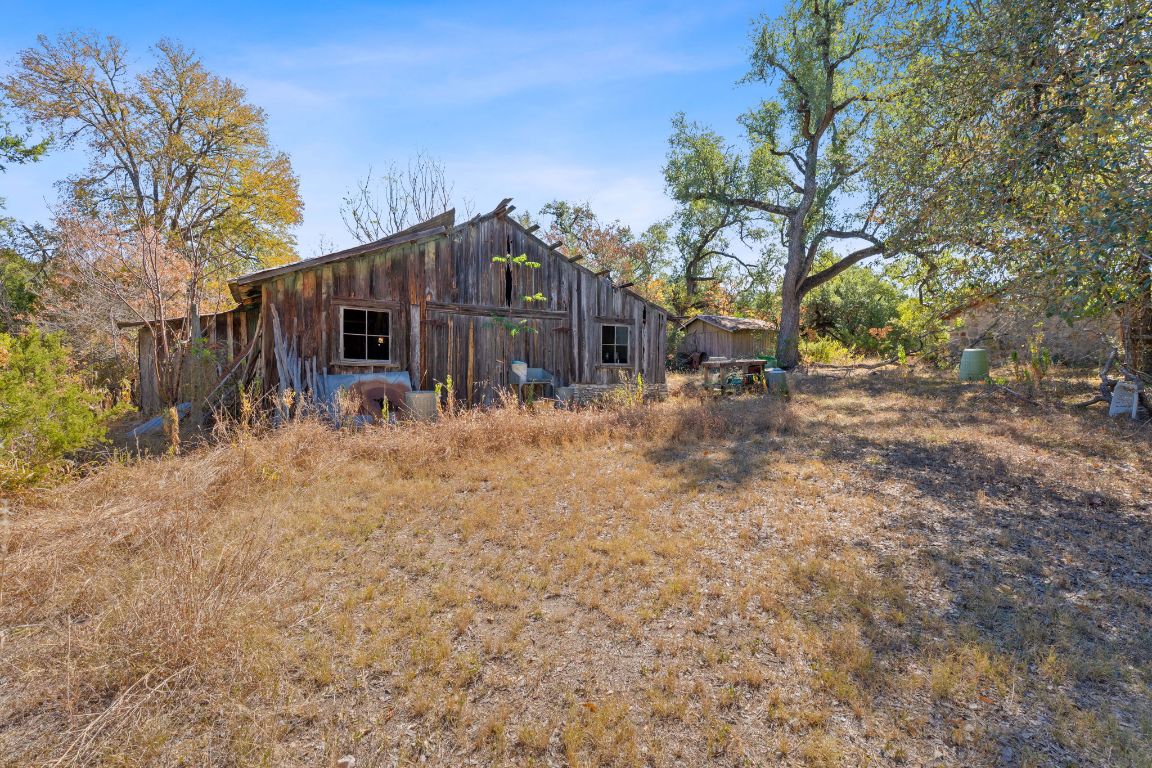 8409 Appaloosa Run Austin, TX 78737 - Photo 14 of 40 a backyard of a house with table and chairs under a large tree