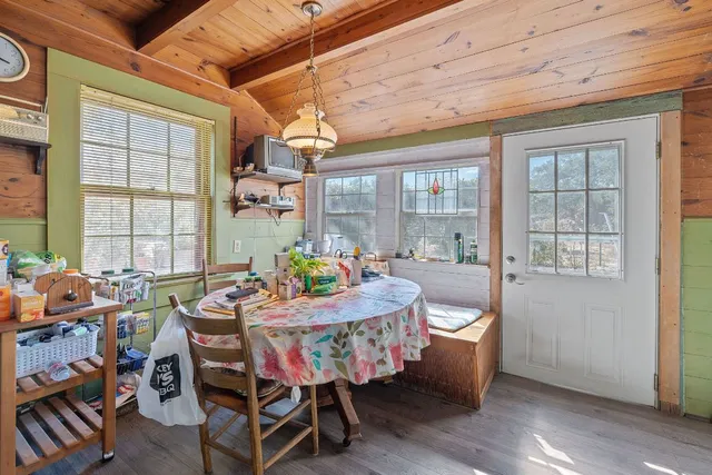 a dining room with furniture a chandelier and wooden floor