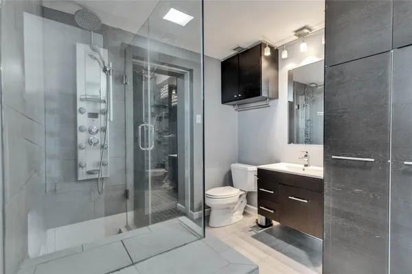 a bathroom with a sink a toilet and shower