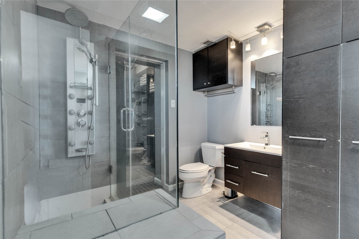 1801 Lavaca Street, Unit 5D Austin, TX 78701 - Photo 11 of 26 a bathroom with a sink a toilet and shower
