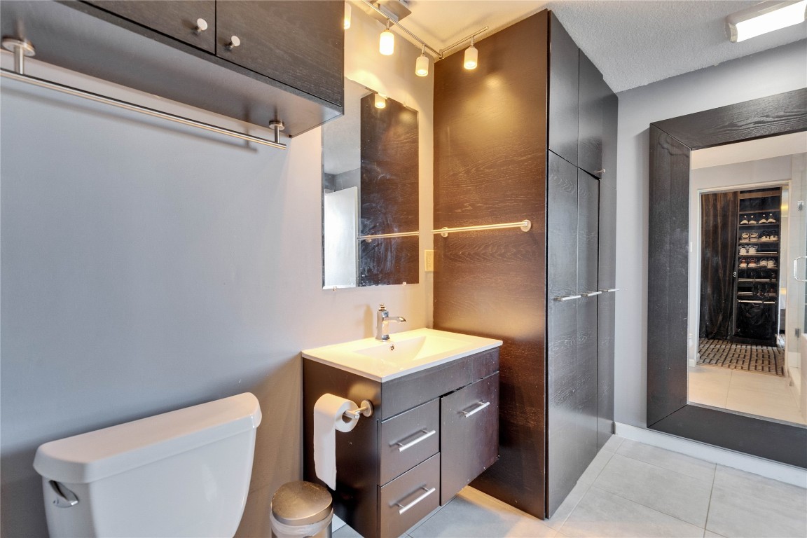 1801 Lavaca Street, Unit 5D Austin, TX 78701 - Photo 13 of 26 a bathroom with a sink a toilet and shower
