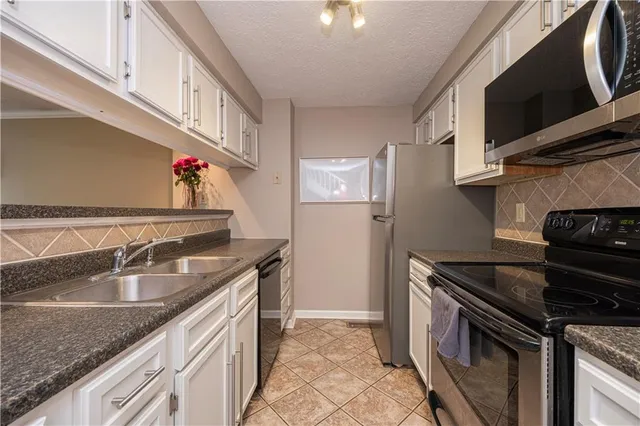 a kitchen with stainless steel appliances granite countertop a sink and a stove