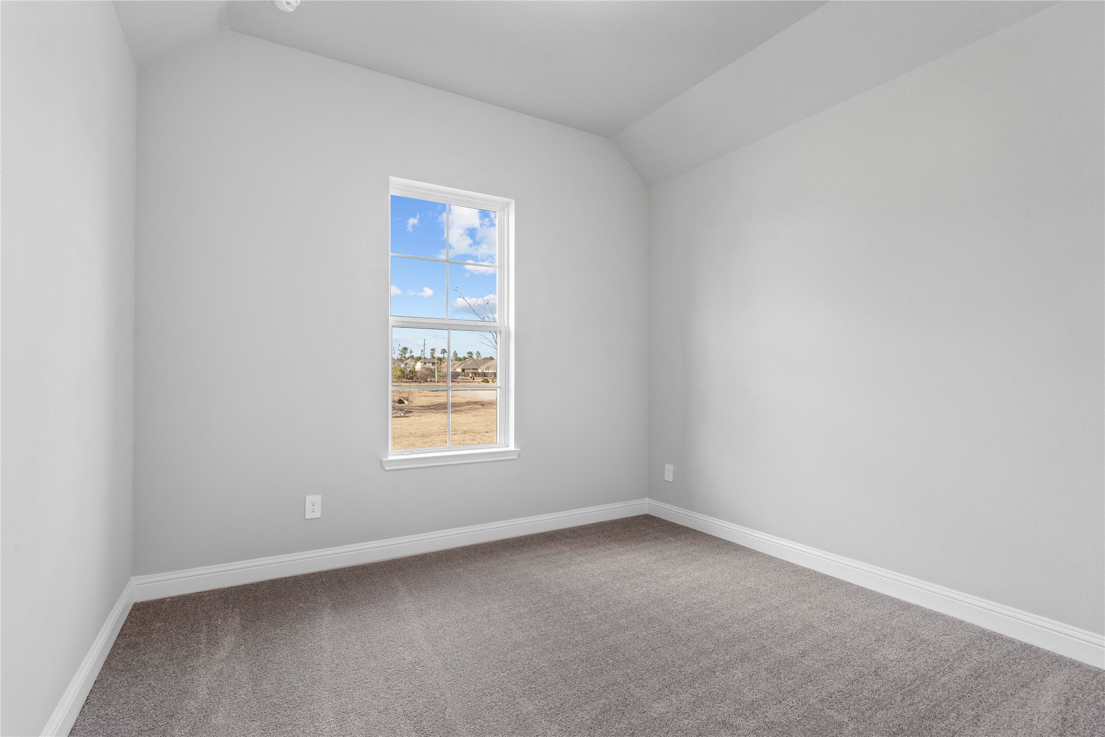 17020 Sweet Iris Court Conroe, TX 77302 - Photo 11 of 50 Tucked peacefully in the front of the home is this secondary bedroom featuring neutral toned walls, sloped ceiling, large window, plush carpet flooring, and a walk-in closet.