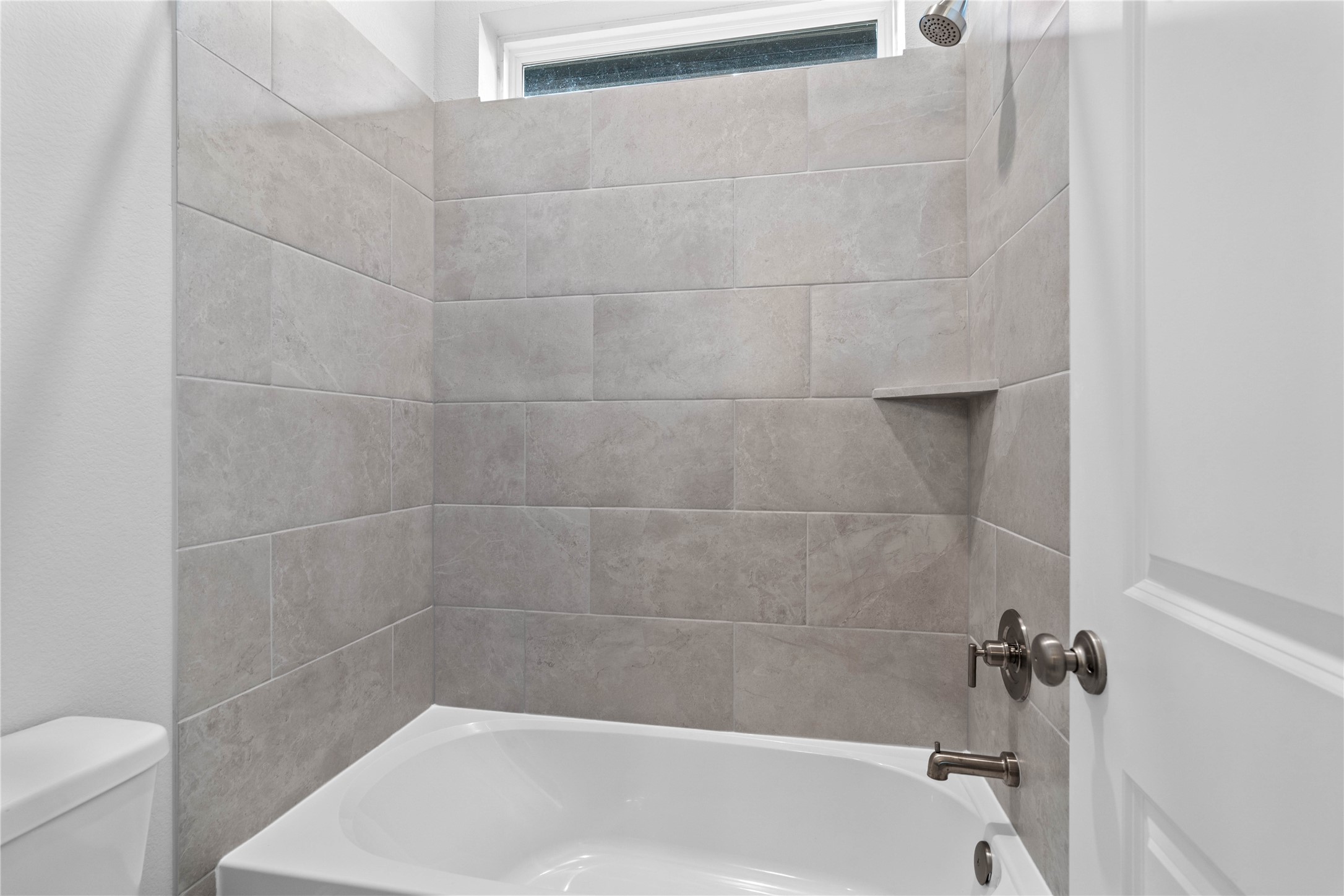 17020 Sweet Iris Court Conroe, TX 77302 - Photo 13 of 50 This modern bathroom features a tub/shower combination with tile surround.