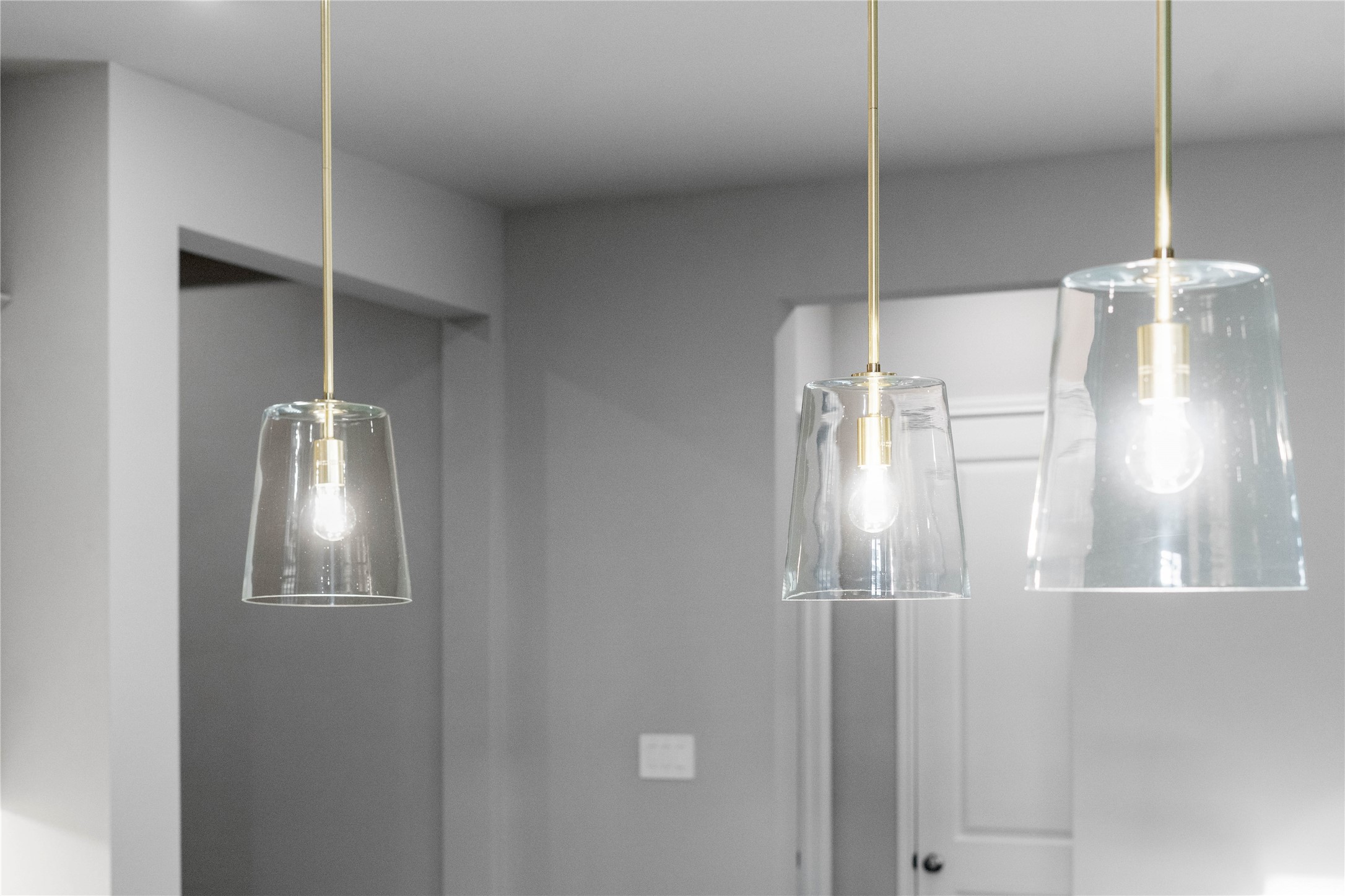 17020 Sweet Iris Court Conroe, TX 77302 - Photo 22 of 50 Three exquisite pendant lights elegantly hang above the kitchen island, providing focused task lighting and a touch of refined style.