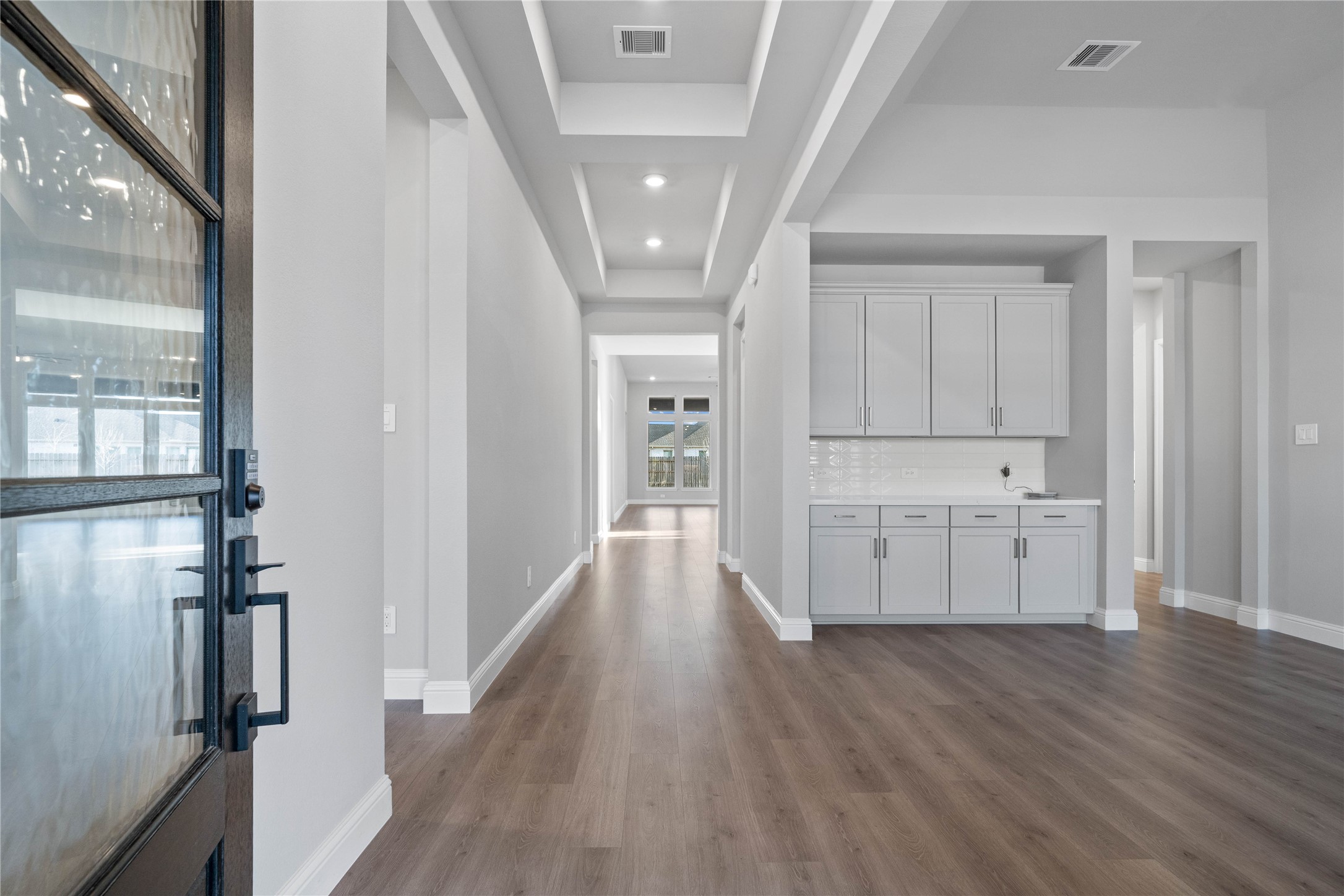 17020 Sweet Iris Court Conroe, TX 77302 - Photo 7 of 50 This sophisticated entryway serves as a grand first impression, featuring a gallery-style layout with a recessed tray ceiling and integrated LED pot lights that emphasize the home's height and open-concept design.