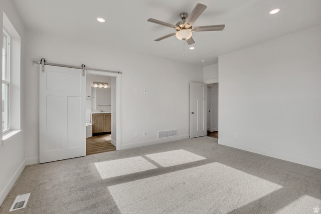 3839 West 825 North, Unit WF18 West Point, UT 84015 - Photo 14 of 22 Unfurnished bedroom featuring a barn door, connected bathroom, light colored carpet, recessed lighting, and a ceiling fan
