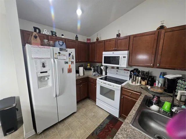 a kitchen with stainless steel appliances granite countertop a refrigerator sink and stove
