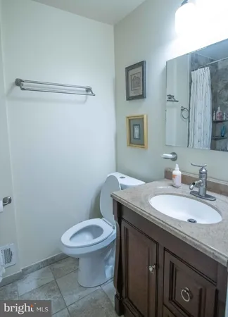 a front view of a house with a garden and trees