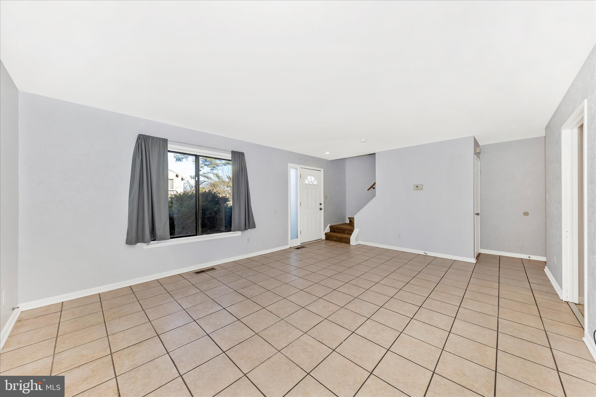 9989 Ridgeline Drive Montgomery Village, MD 20886 - Photo 6 of 26 a view of an empty room with window and a chandelier fan