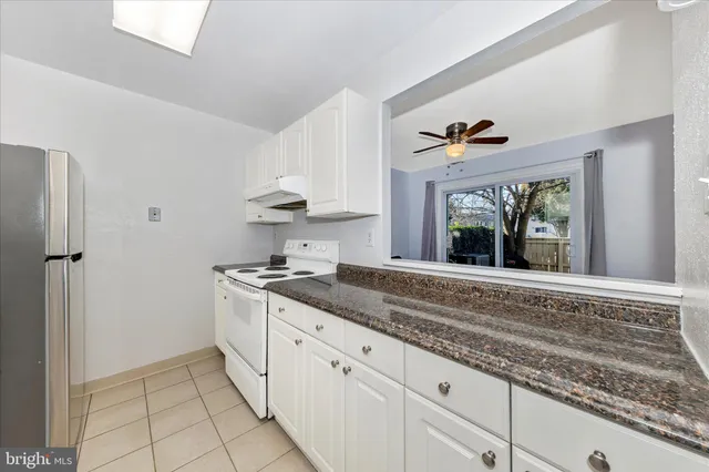 a kitchen with granite countertop a sink stainless steel appliances and cabinets