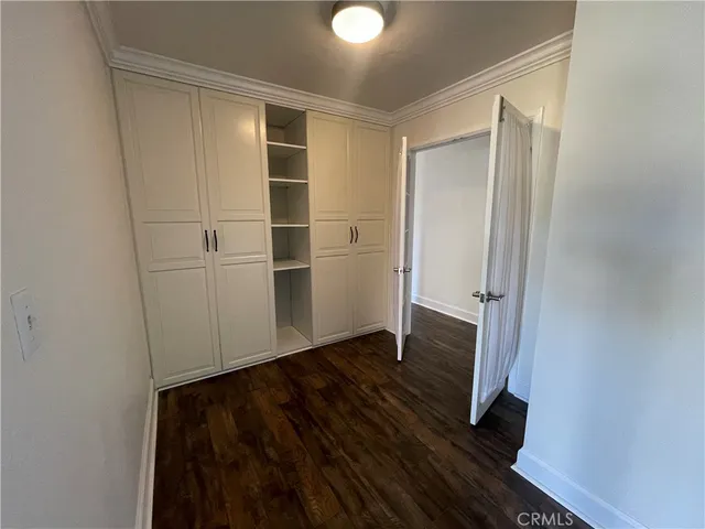 an empty room with wooden floor and closet