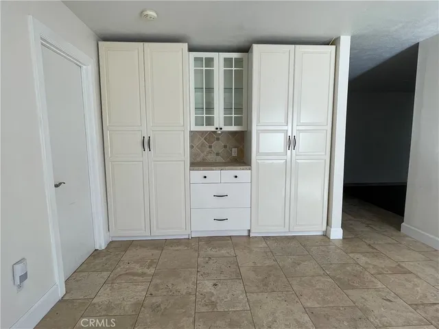 an empty room with cabinet and mirrors