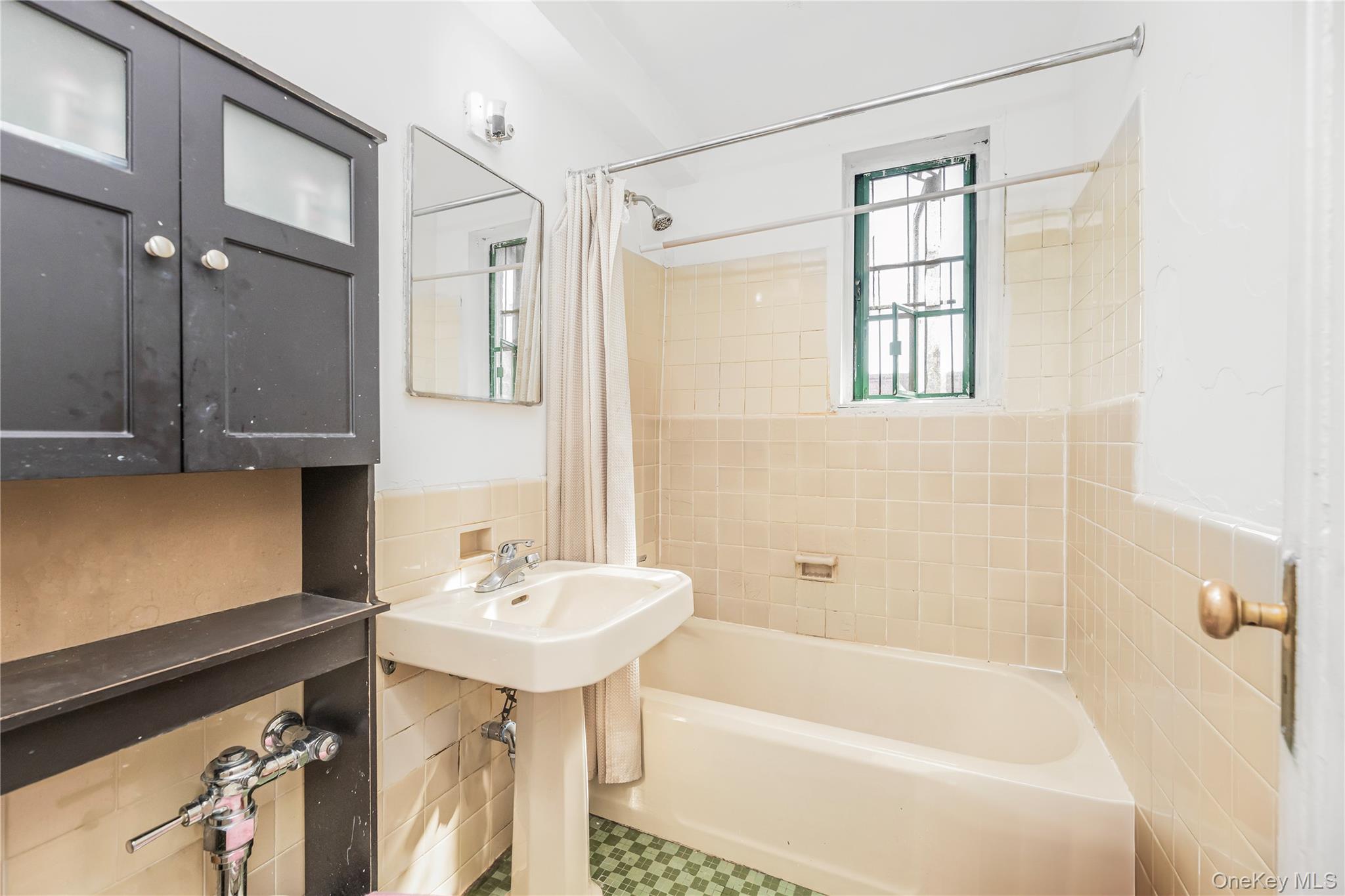 1540 Unionport Road, Unit 7F Bronx, NY 10462 - Photo 4 of 16 a bathroom with a sink a mirror and a bathtub